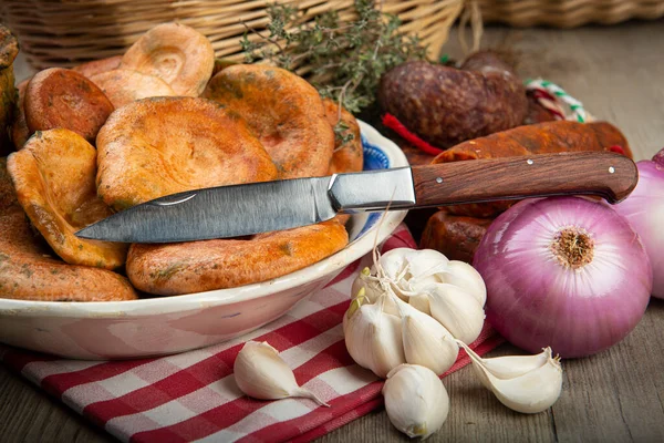 Safran süt kapakları mutfak masasında İspanyol sosisleri.