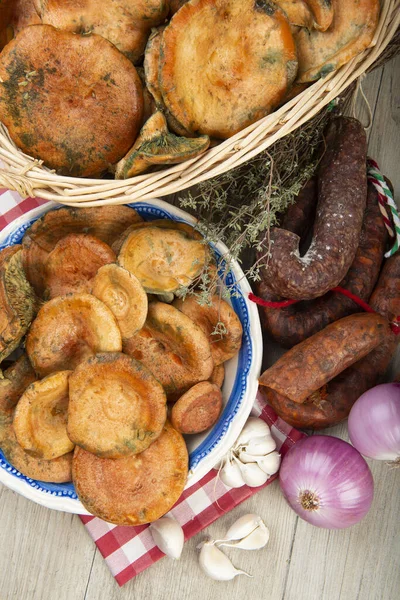 Safran süt kapakları mutfak masasında İspanyol sosisleri.