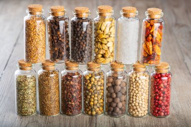 Farklı baharat ve biber çeşitleri içeren cam kavanozlar.