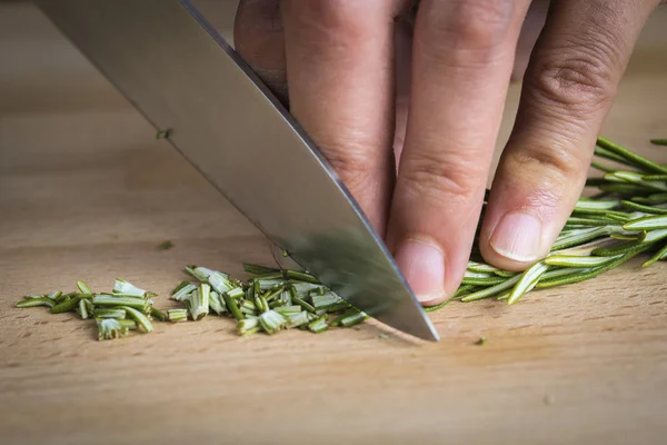 Chef-kok hakken van een tak van rozemarijn — Stockfoto