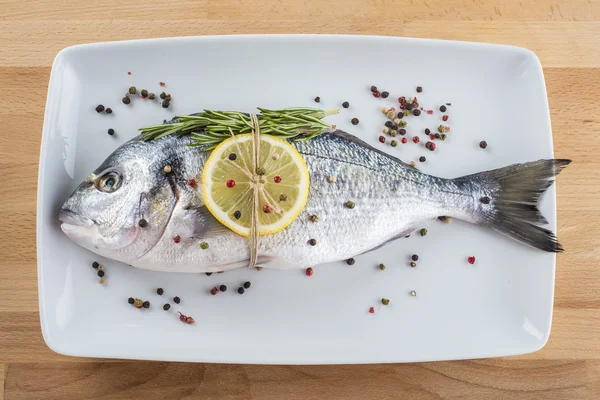 用香料放在盘子上的镀金头海鲷鱼 — 图库照片