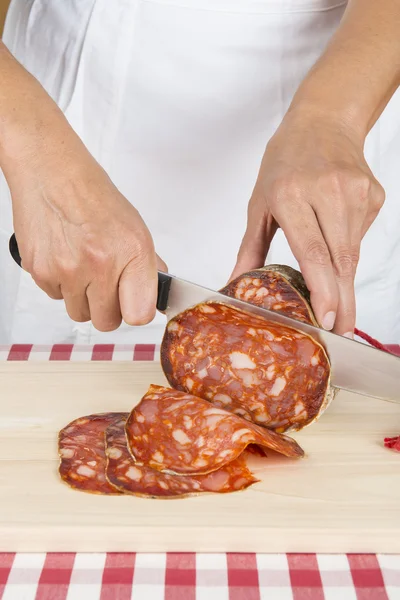 Macellaio affettare una salsiccia spagnola chiamata morcon — Foto Stock