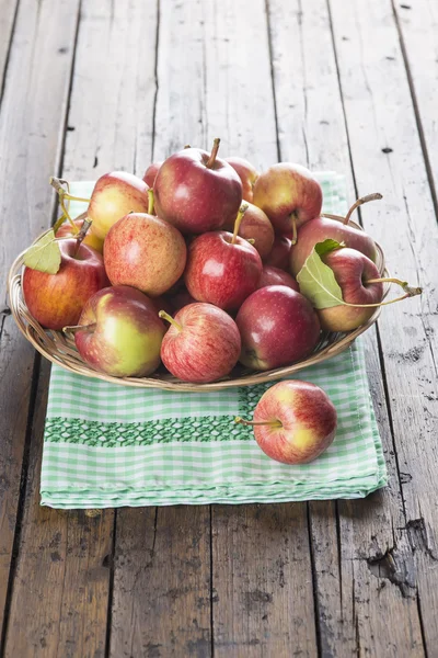 Korb mit Äpfeln auf einem Holztisch — Stockfoto