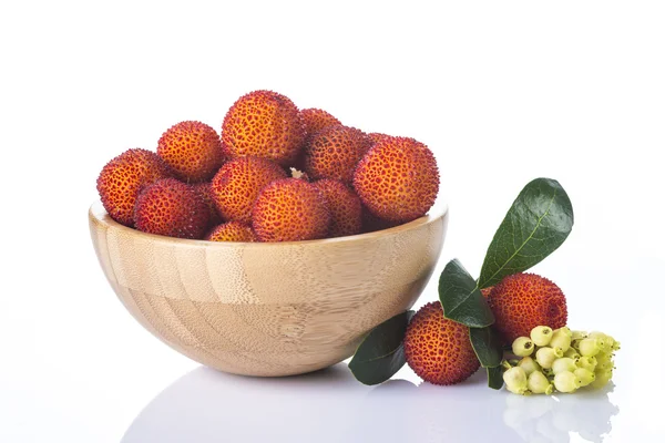 Träskål med arbutus unedo frukter — Stockfoto