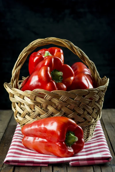 Korb mit roten Paprika auf dem Tisch der Küche — Stockfoto