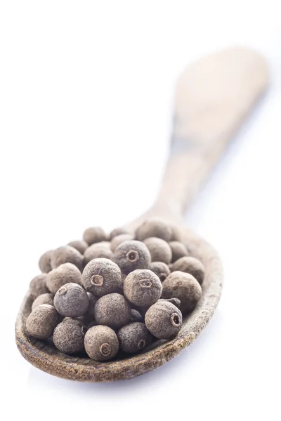 Cuchara con pimienta de Jamaica sobre fondo blanco — Foto de Stock