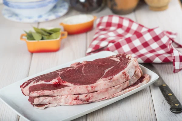 Raw steaks on the kitchen table — Stock Photo, Image