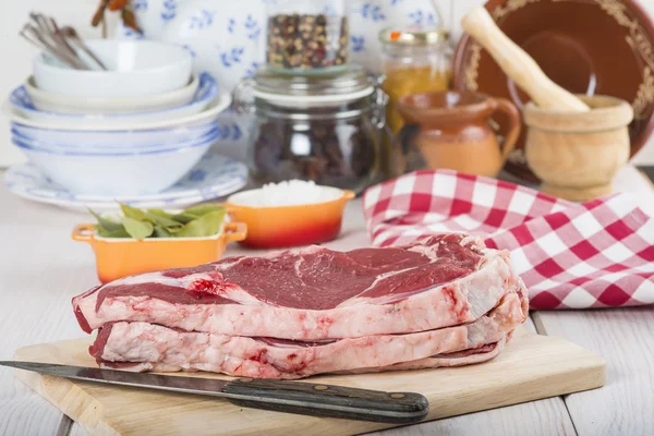 Raw steaks on the kitchen table — Stock Photo, Image