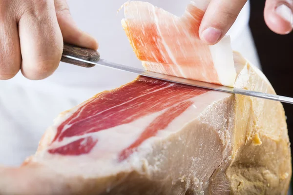 Professionelles Schneiden von Serrano-Schinken — Stockfoto