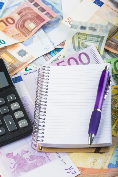 Калькуляторная ручка и ноутбук на деньги — стоковое фото