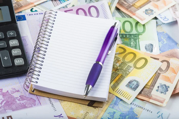 Caneta calculadora e caderno sobre o dinheiro — Fotografia de Stock
