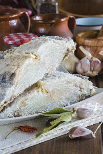 Bacalhau salgado cortado na mesa da cozinha — Fotografia de Stock