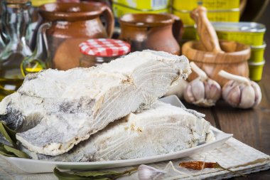 Salted cod cut on the table of the kitchen clipart