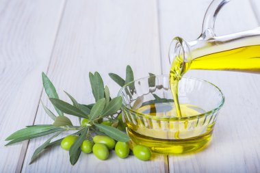 Bakire ekstra zeytin yağı bir kapta dökülen şişe