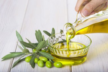 Bakire ekstra zeytin yağı bir kapta dökülen şişe