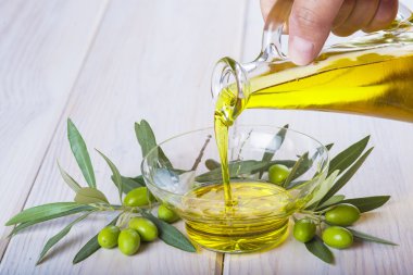 Bakire ekstra zeytin yağı bir kapta dökülen şişe