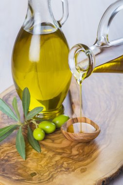 Ekstra sızma zeytinyağı bir kaşık dökülen şişe