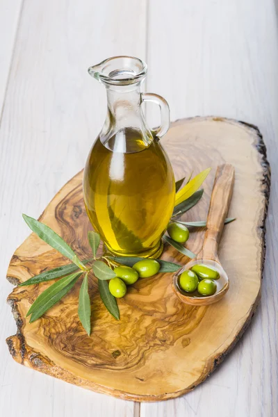 Olive oil with raw olives and leaves — Stock Photo, Image