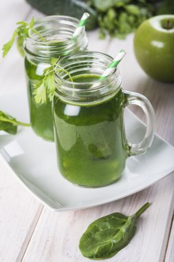 Beyaz ahşap zemin üzerine yeşil smoothie