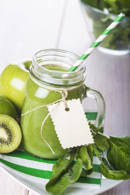 Beyaz ahşap zemin üzerine yeşil smoothie