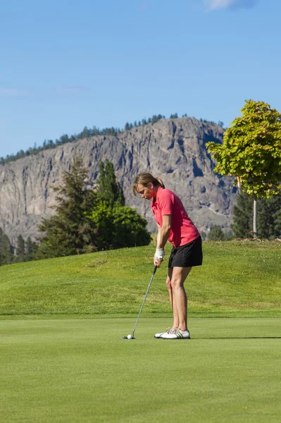 Kvinnliga golfspelare på puttinggreen Stockfoto