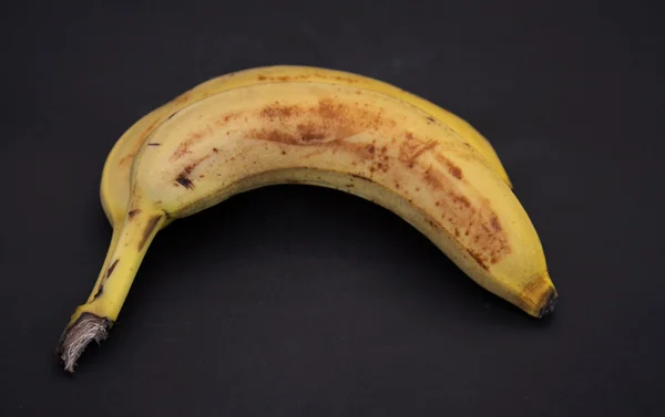 A sötét háttéren érett banán gyümölcs — Stock Fotó