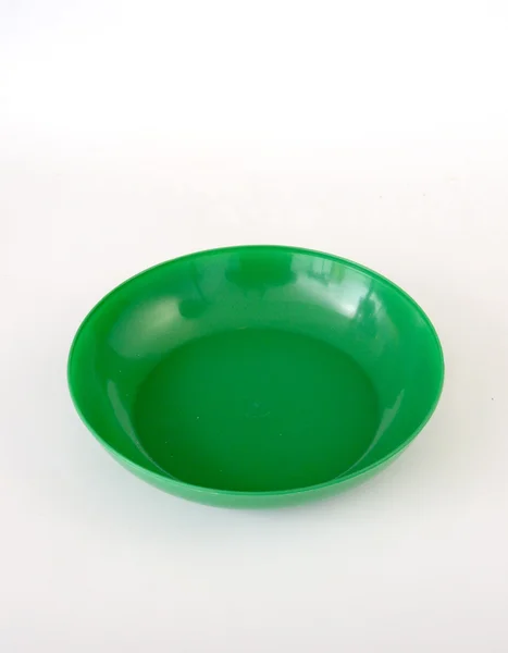 파란색 배경에 녹색 플라스틱 접시 — 스톡 사진
