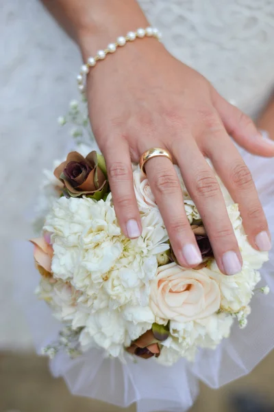 Händerna på en brud med bröllop blomma — Stockfoto