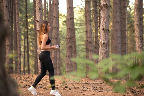 Yound sexy blond meisje met fles een water wandelen — Stockfoto