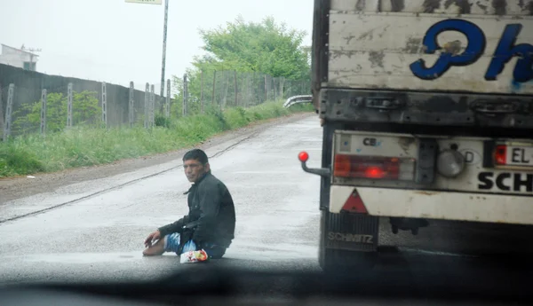 近爱尔巴桑、 阿尔巴尼亚。16 日 2011年-阿尔巴尼亚残障的男人在非常危险的境地，4 日在繁忙的公路近爱尔巴桑、 阿尔巴尼亚求助 16,2011. — 图库照片