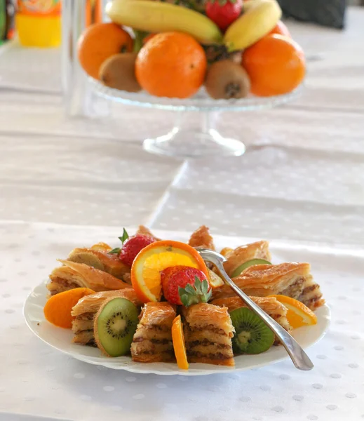 Сладкая турецкая пахлава и свежие фрукты в тарелке — стоковое фото