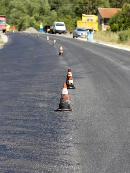 Conos en un camino de asfalto durante la restauración —  Fotos de Stock