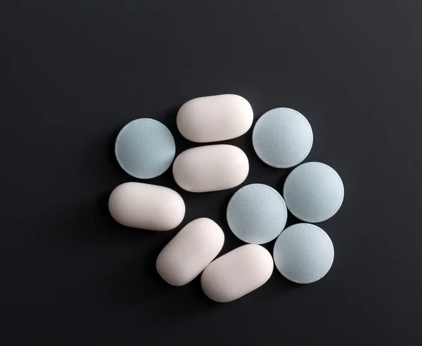 Hvite godterier og blå piller, søte og bitre – stockfoto
