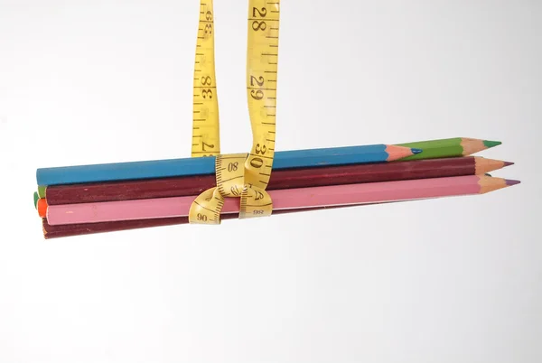 Barevné tužky nahg na Svinovací metr, izolované na bílém pozadí. — Stock fotografie
