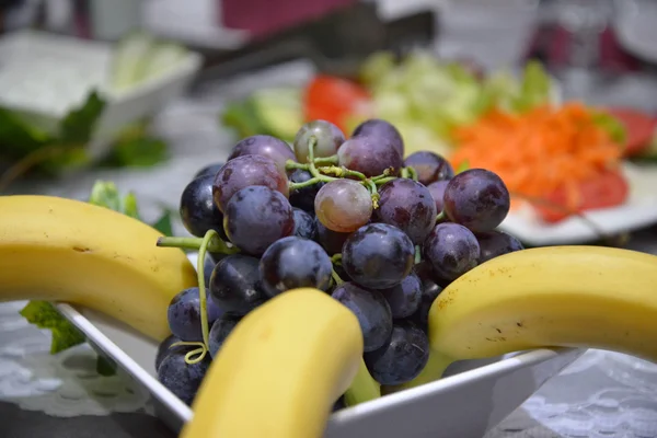 Бананы и спелый красный виноград на столе — стоковое фото