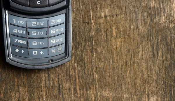 Old mobile phone on a wooden background — Stock Photo, Image