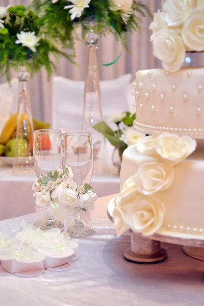 Dvě sklenice šampaňského a svatební dort — Stock fotografie