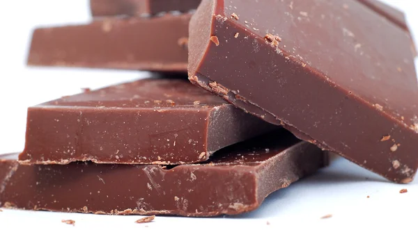 Gebroken chocolade stukken op witte achtergrond — Stockfoto