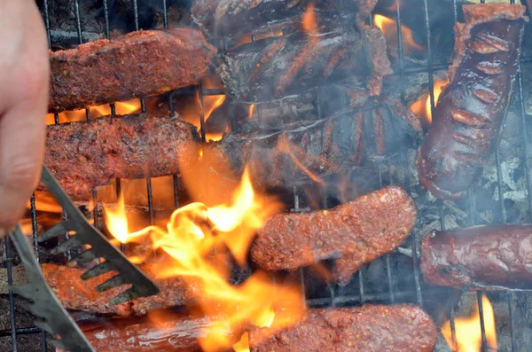 Grilling sausages on barbecue grill — Stock Photo, Image