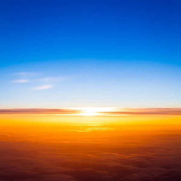 Puesta de sol sobre las nubes desde la ventana del avión — Foto de Stock