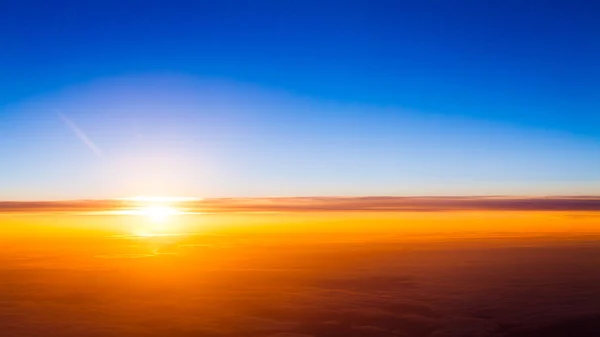 Puesta de sol sobre las nubes desde la ventana del avión — Foto de Stock