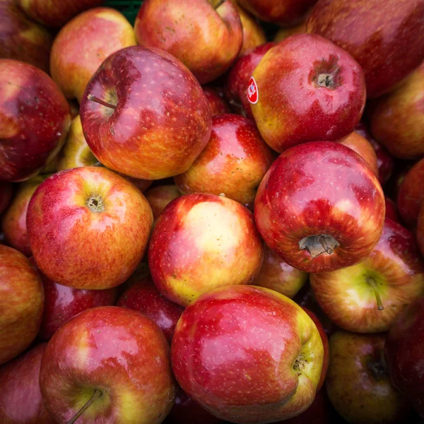 Omenat sulkeutuvat torilla. Punaiset omenat tausta — kuvapankkivalokuva