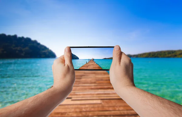 Tourism Concept. Old wooden pier. paradise island. Hand with a s — Stock Photo, Image