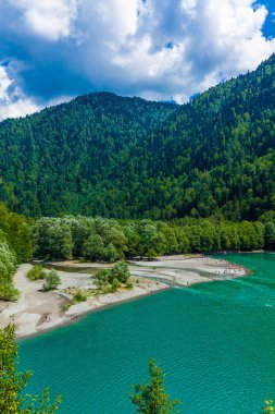 Göl, orman ve dağlarla güzel bir manzara.