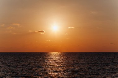 Denizin üzerinde güzel bir gün batımı. Sudaki günbatımının yansıması..