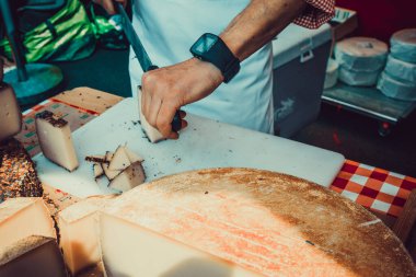 İşçi peyniri dilimliyor. Peynir doğramaya yakın.