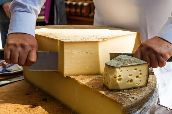 Homem cortando pedaço de queijo — Fotografia de Stock