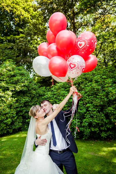 Kaukasiska bröllopsparet med ballonger — Stockfoto