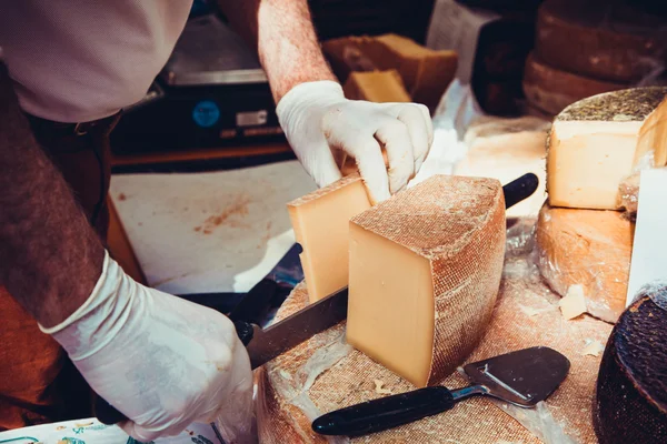 Lavoratore affettare il formaggio. Primo piano del taglio del formaggio. — Foto Stock