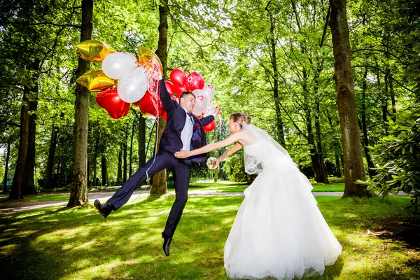 Bride and groom with balloons — Stock Photo, Image